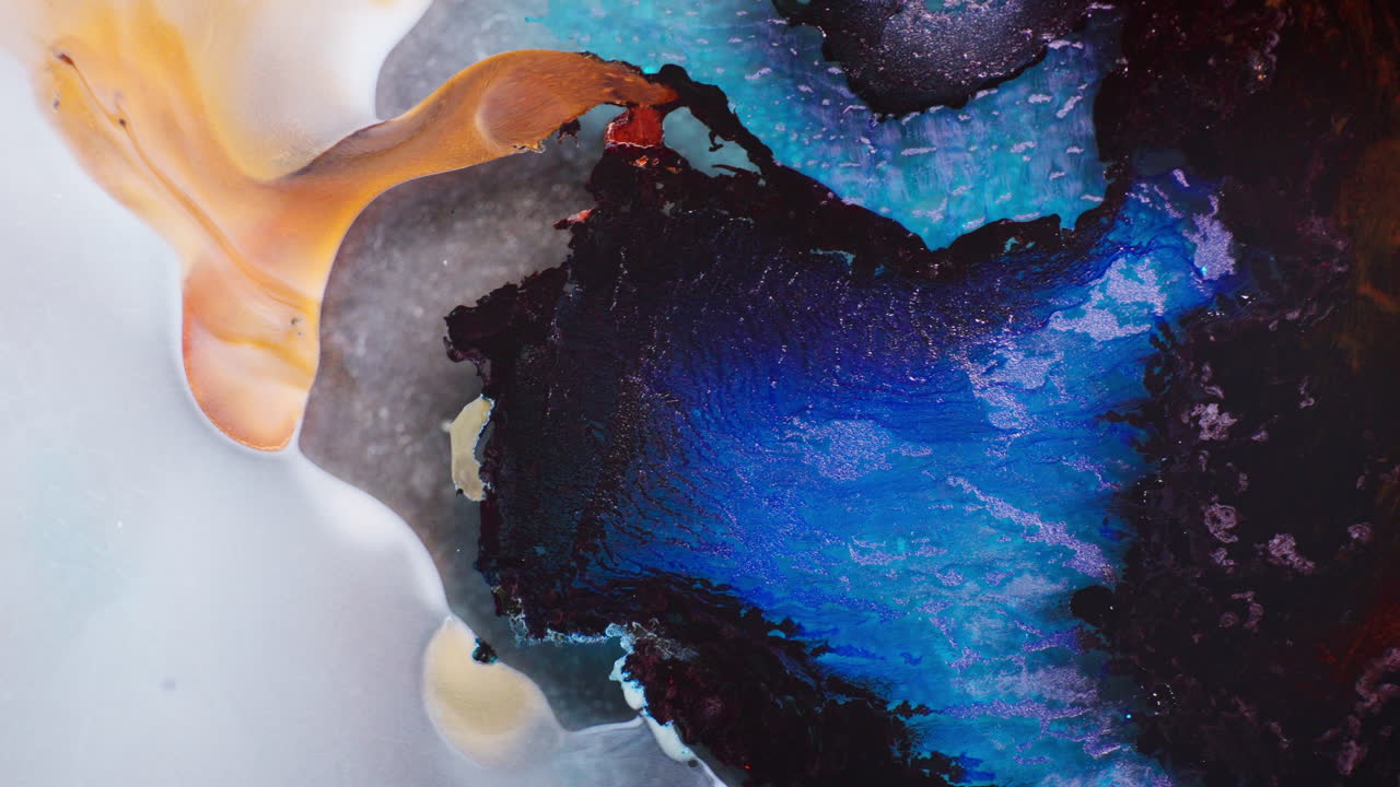 Swirling mass of dark blue and black inks mixing in liquid. Macro view