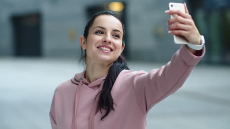 Close-up-smiling-woman-waving-hand-to-camera.-Happy-girl-using-mobile-phone