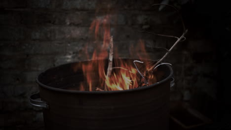 fire burning in a metal container outdoors at night