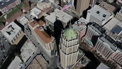 Overhead-drone-shot-of-the-American-flag-atop-of-the-Tower-Life-Building-in-San-Antonio,-Texas