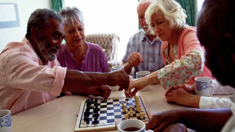 active mixed-race senior people playing chess game in the nursing home 4k