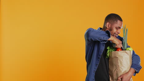 joven afroamericano escaneando todos los productos ecológicos en el estudio