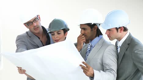 International group of architects studying blueprints