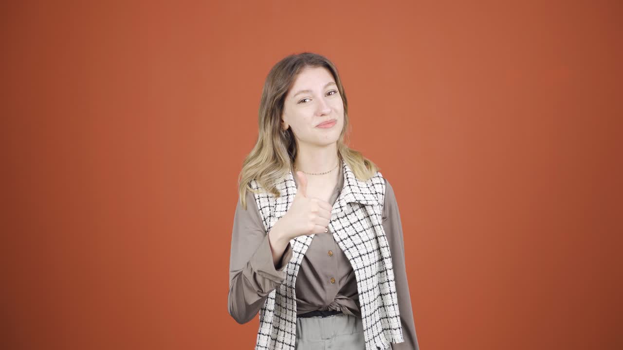 젊은 여성이 카메라에 긍정적인 제스처를 하고 있습니다.