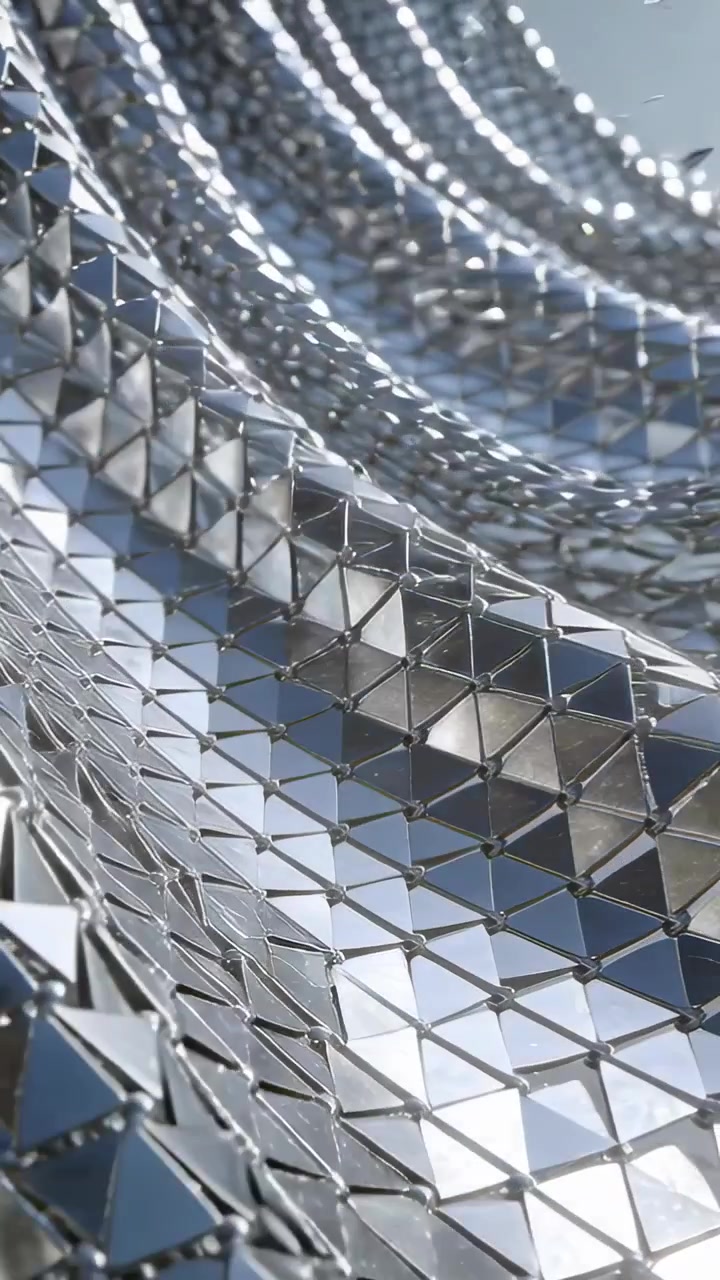 Video verticale: Una maglia triangolare scintillante forma onde in uno studio, con la luce che provoca bagliori sui nodi.