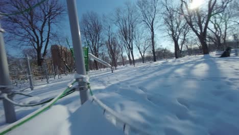 fpv shot of playground in winter at parc lafontaine, montreal, canada