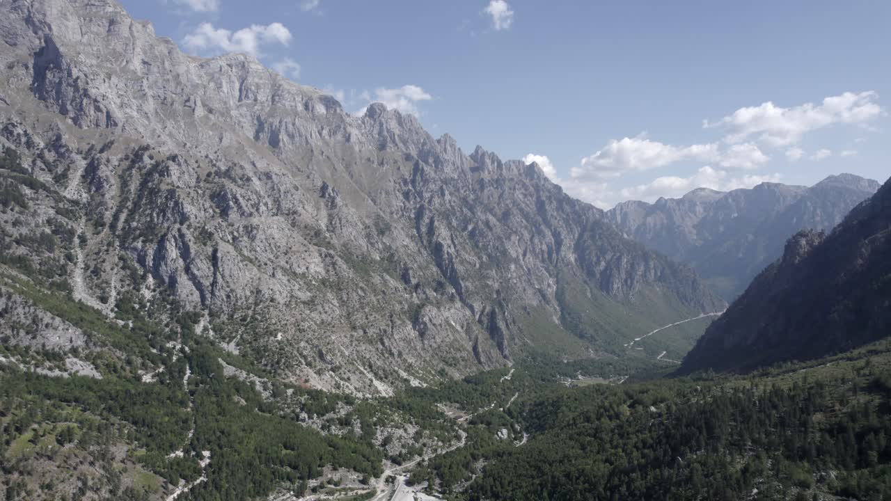 video de drone frontal avanzando entre las montañas en la carretera azem hajdari en el valle de valbona y el río rrogam i shale