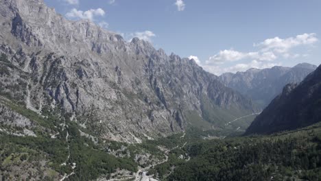 video drone frontale che avanza tra le montagne sulla strada azem hajdari nella valle di valbona e il fiume rrogam i shales