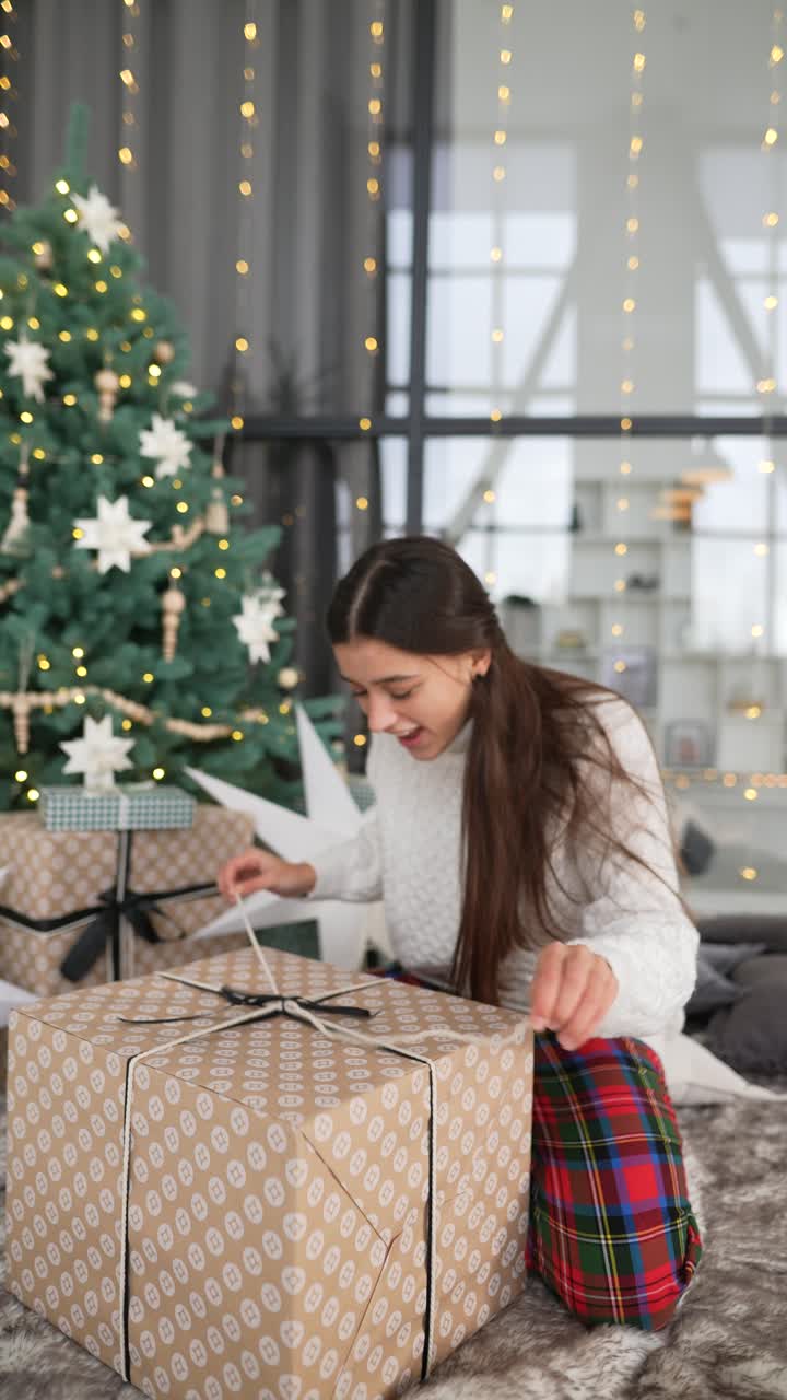 chica emocionada abriendo un regalo de navidad