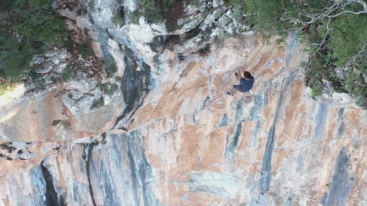 escalador deportivo descendiendo en rappel por la pared de una montaña