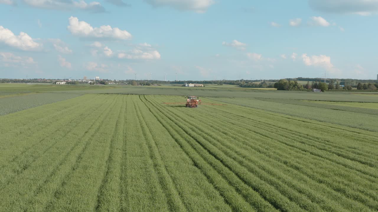 Drone - Ripresa aerea di un trattore che spruzza tossine - Roundup su un campo di mais in una giornata di sole, 30p.
