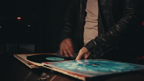 man listening to vinyl records at night