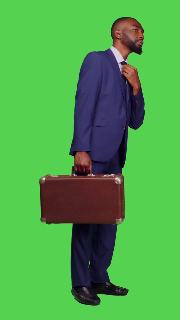 Vertical video: Side view of corporate worker carrying suitcase at business company
