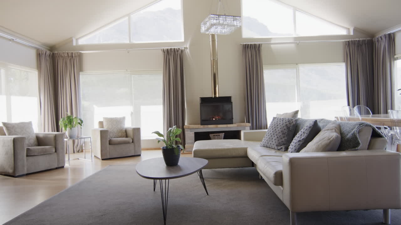 Algemeen beeld van een moderne woonkamer met open haard en meubels, met kopieerruimte, slow motion