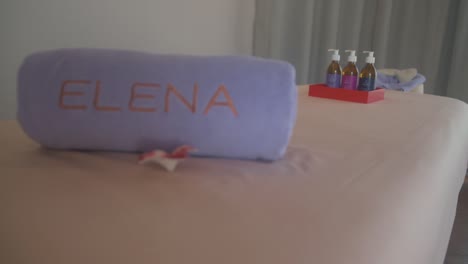 una cama de masaje con toalla morada y aceites en un resort de maldivas