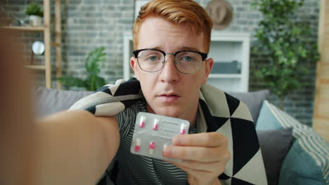 young man taking medication at home