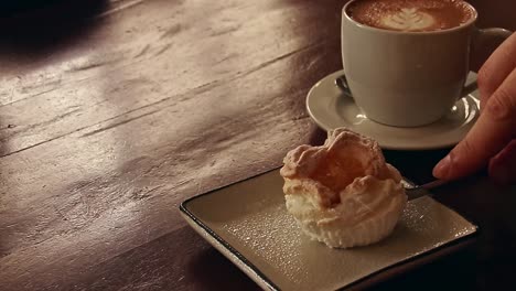 corte de tenedor en un postre filipino llamado brazo de mercedes cupcake emparejado con una taza de capuchino, calidez y comodidad del estado de ánimo de otoño