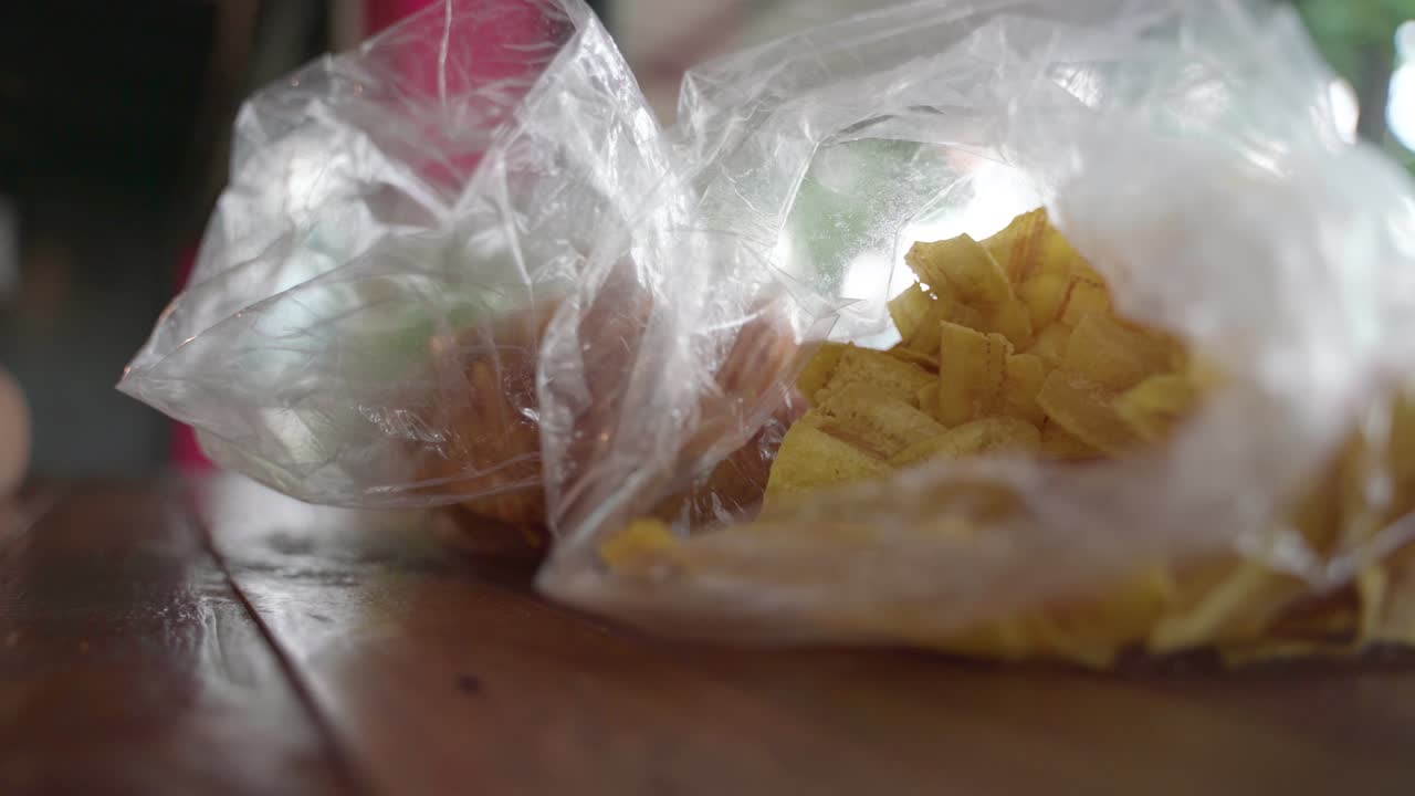 recogiendo a mano un bocadillo frito y crujiente de papas fritas de plátano