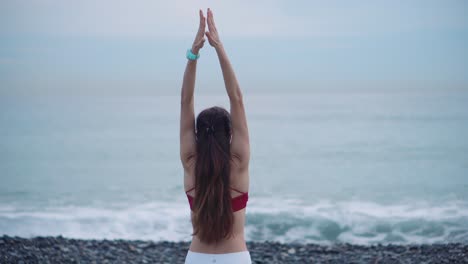 mujer practicando yoga en una hermosa playa