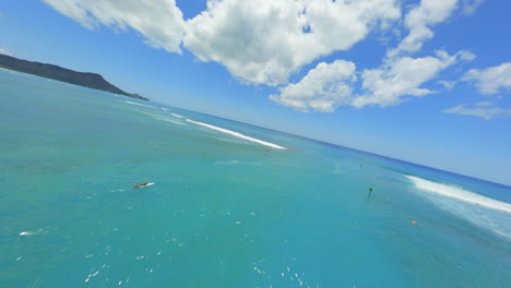 aerial view of calm ocean waves and surfers on a sunny day in hawaii