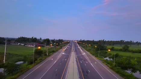 drone footage traveling along a highway through a city in thailand early in the morning