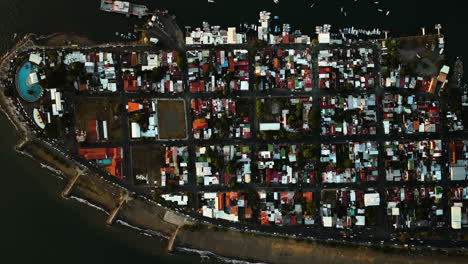 fotografía de un dron desde arriba que se eleva sobre la ciudad de puntarenas, puesta de sol en costa rica