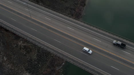 Birds-Eye-Aerial-View-of-Bridge-Traffic-Above-Deep-River-Canyon