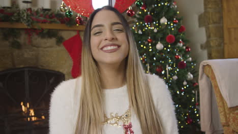 young woman talking and waving to camera during christmas video call