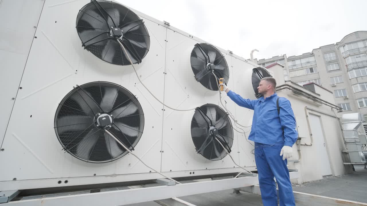 기술자는 열 영상 적외선 온도계를 사용하여 응축 유 열 교환기를 확인합니다.