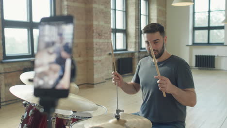 drummer filming video lesson with phone