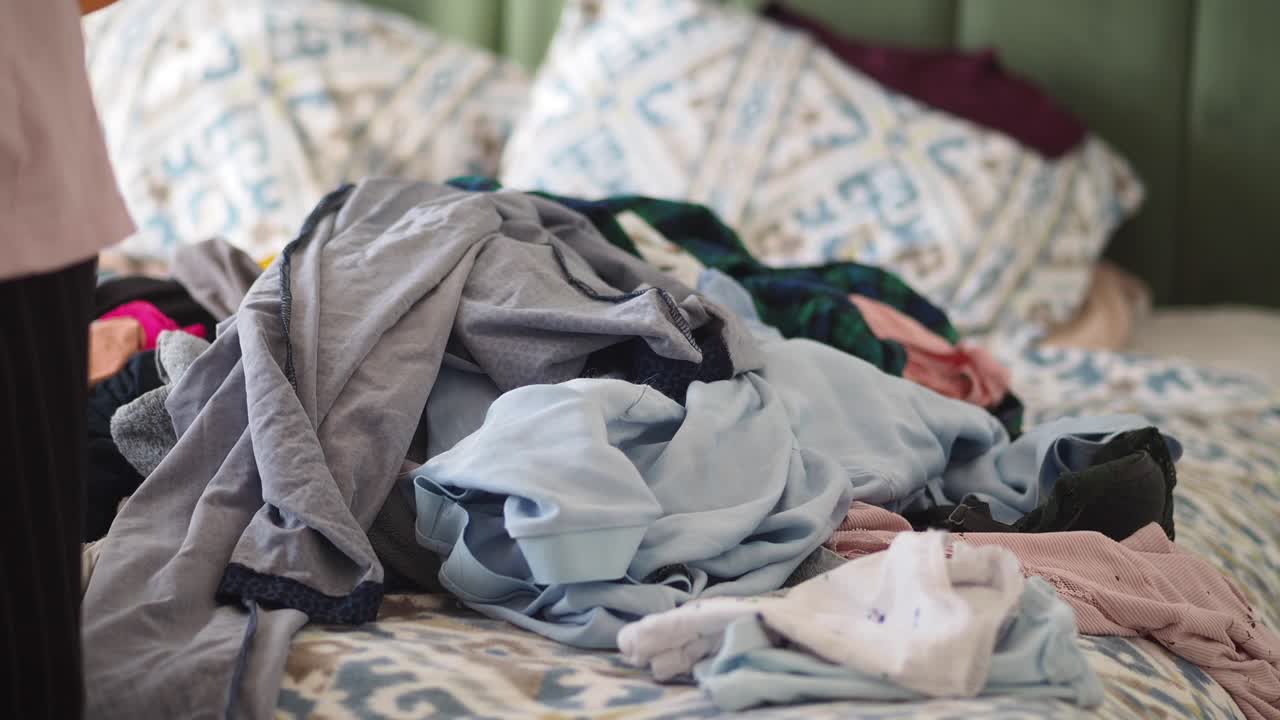 Messy Bedroom with Pile of Clothes on Bed