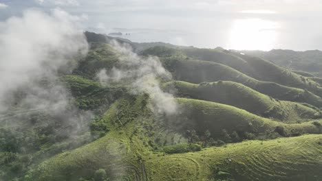 green hills with fog in the foreground - indonesia - nusa penida island