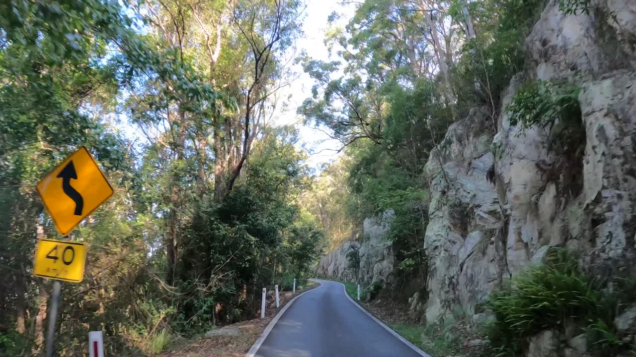 울창한 숲과 바위 절벽을 가로질러 휘어지는 길