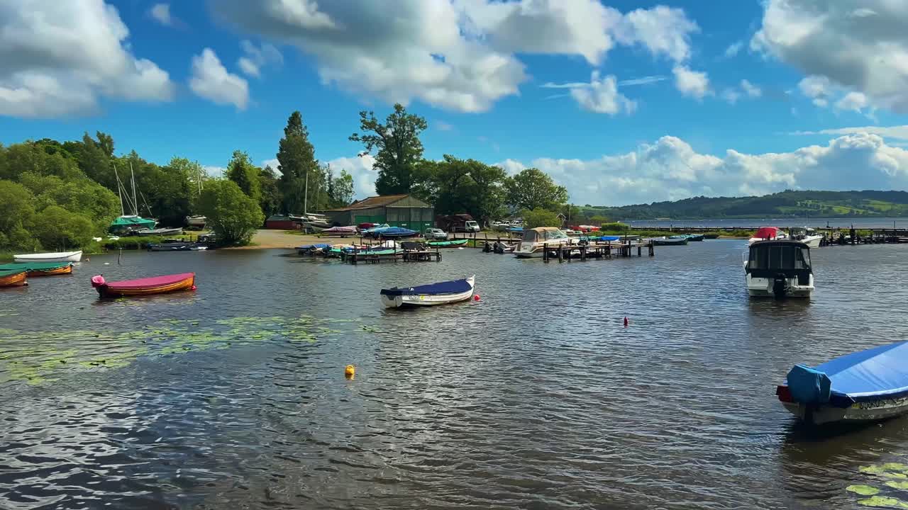 Wooden Boats Anchored On A Lake Near A Seaside Town In Scotland. Wide Shot