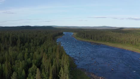 Drone-shot-of-wild-river-in-northern-Sweden-surrounded-by-deep-forest