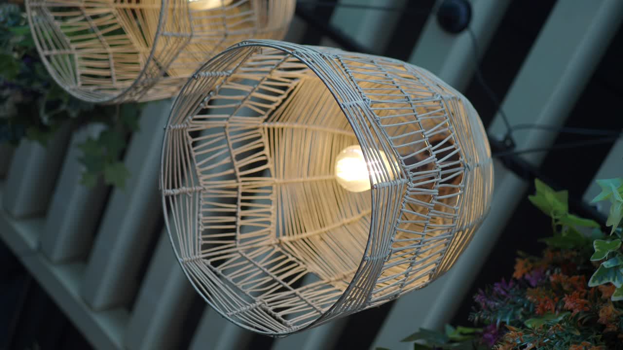 Close-up Lampu Gantung Rotan Dekoratif dengan Bohlam Menyala