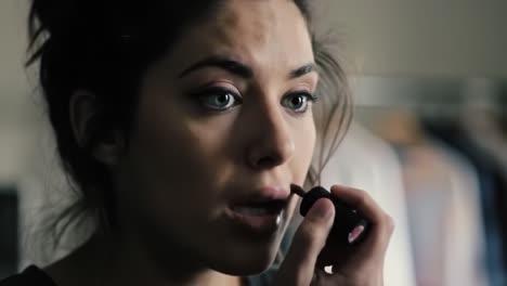 a close-up journey of self-expression: a young woman applying makeup and transforming her look with detailed precision and concentration