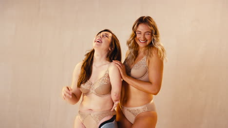 fotografía de estudio de dos amigas una con una prótesis en ropa interior promoviendo la positividad corporal