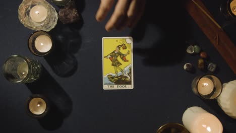 Fotografía-Cenital-De-Una-Persona-Dando-Una-Lectura-De-Cartas-Del-Tarot-Colocando-Las-Cartas-Del-Tonto,-El-Juicio-Y-El-Caballero-De-Copas-Sobre-La-Mesa.