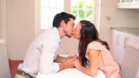 Happy-couple-kissing-at-the-table