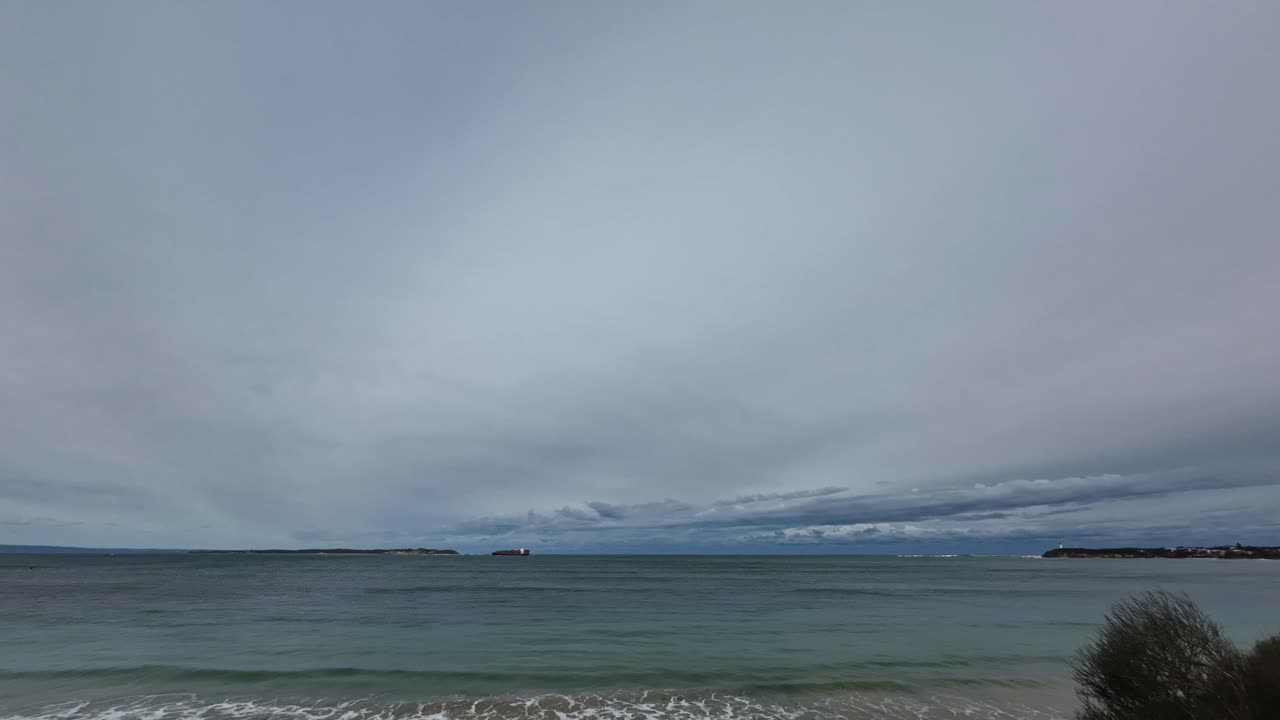 폭풍우에 앞서 항구 필립 만에 진입하는 화물선의 저속 촬영