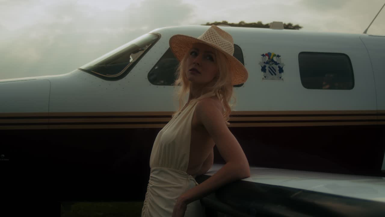 Woman in a Straw Hat near a Private Airplane