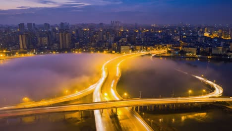 misty city bridge with light trails at night