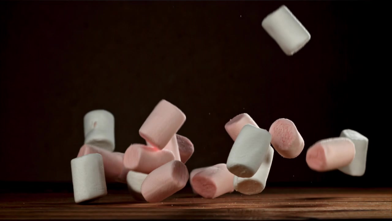 Marshmallow rosa e bianchi che cadono al rallentatore