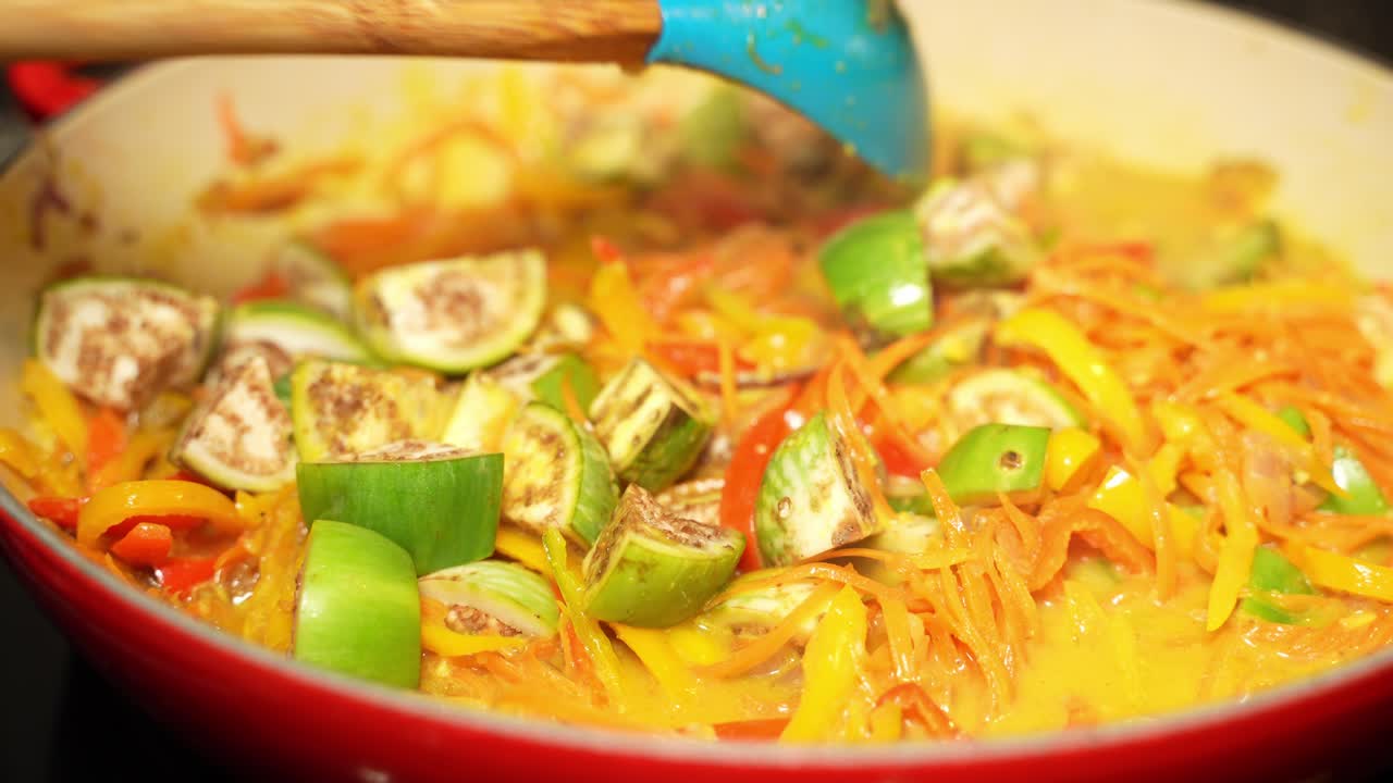 Closeup shot of stirring of veg recipe by a wok spatula.