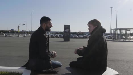 two men talking in a parking lot