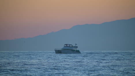 a luxury yacht in the harbor at sunset - slow motion