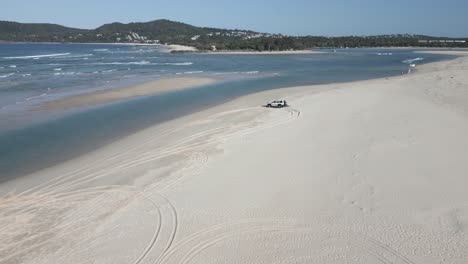 Flyover-truck-on-sand-beach-at-river-bar-of-Noosa-Heads,-Australia