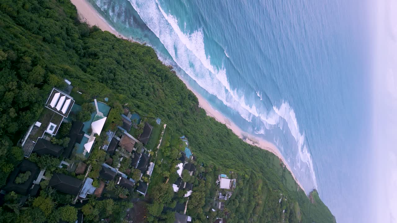 바다 옆에 있는 휴일 오두막의 높은 각도 드론 패닝 샷