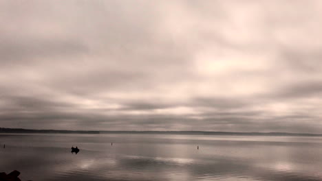 timelapse of boat in the lake with heavy clouds passing by